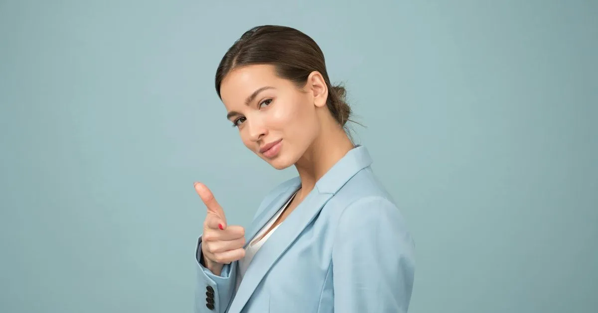 A confident businesswoman pointing toward the camera