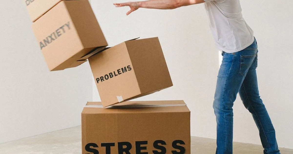 A man knocking over cardboard boxes labelled with problems