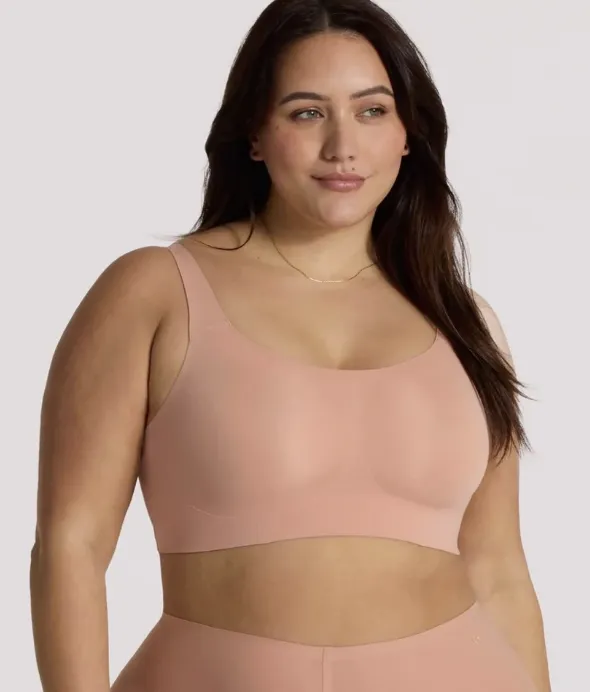 Woman in pink bra grasping measuring tap