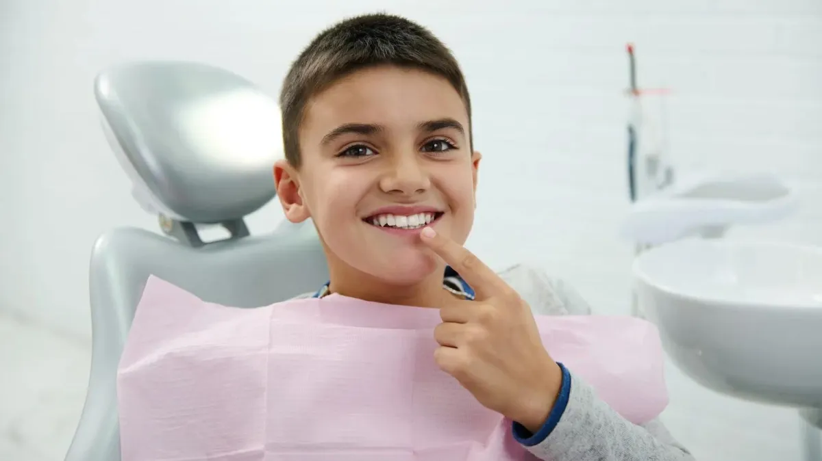 A boy smiling with a good teeths after his pediatric orthodontic treatment. 