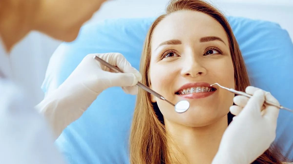Woman with braces smiling during a dental exam