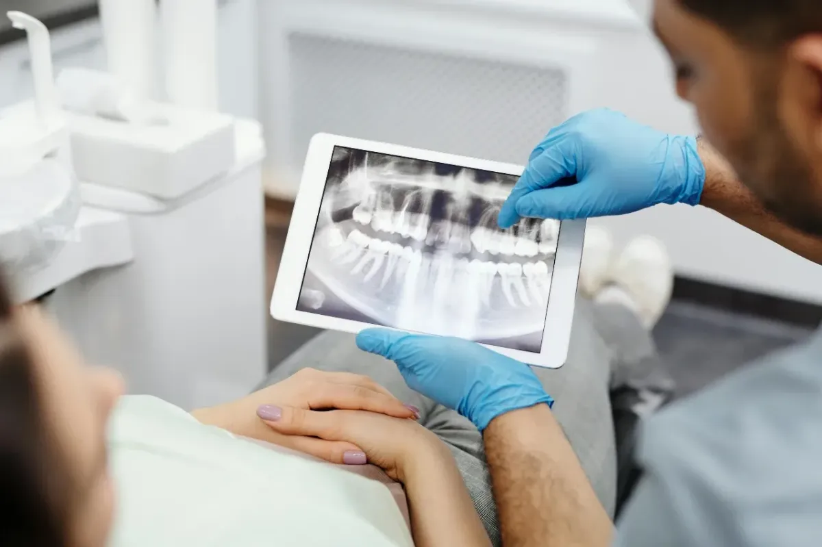 Orthodontist holding and xray and reviewing it with a patient