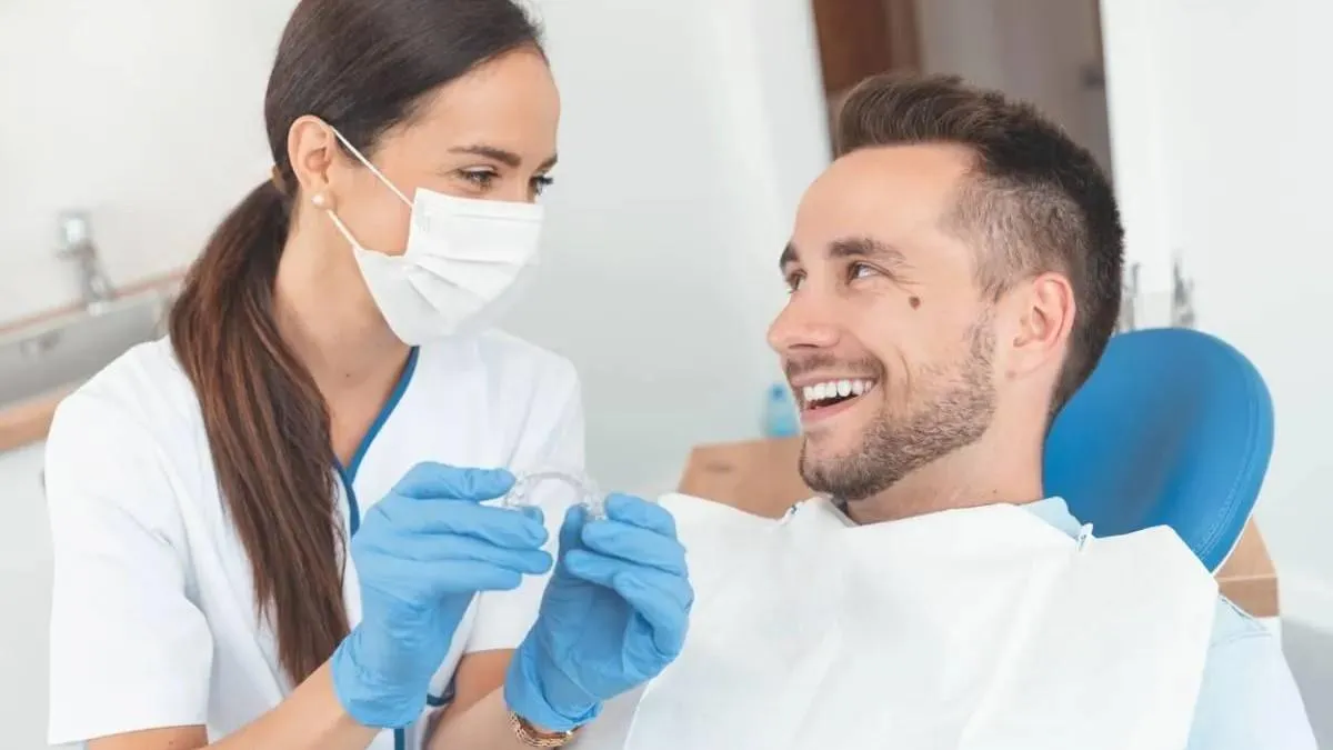 Orthodontist showing an Invisalign to a smiling patient in a Orthodontic clinic.