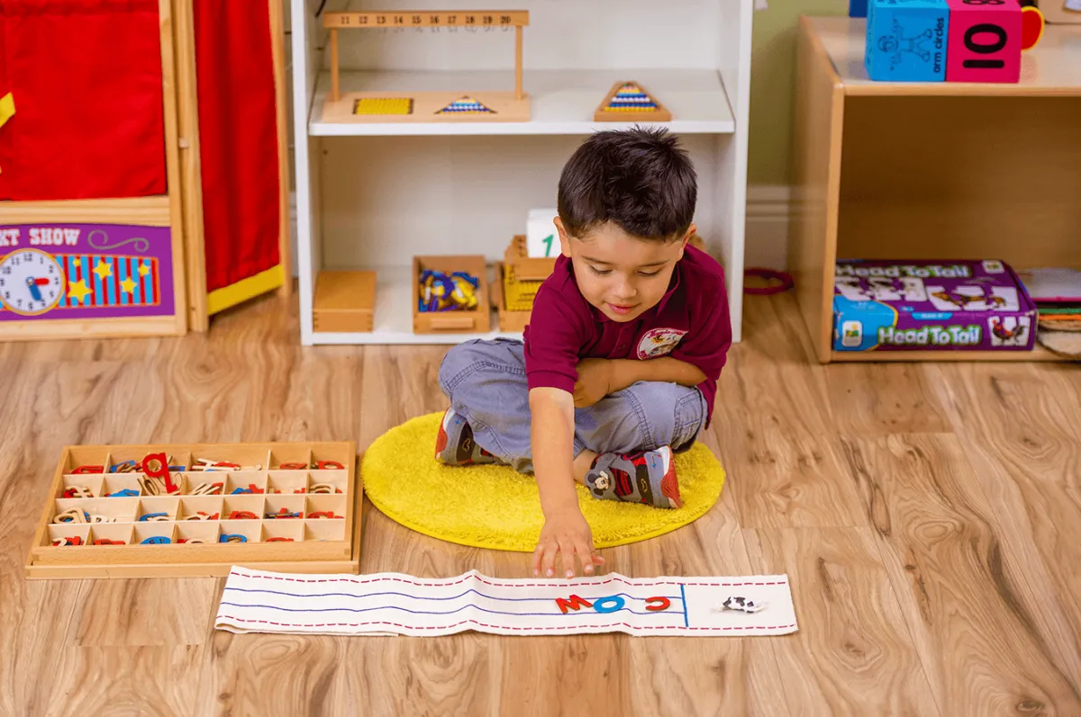 Child playing on ground with letters