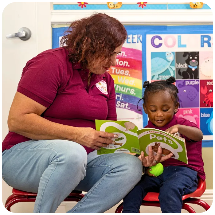 Teacher helping child learn with picture book