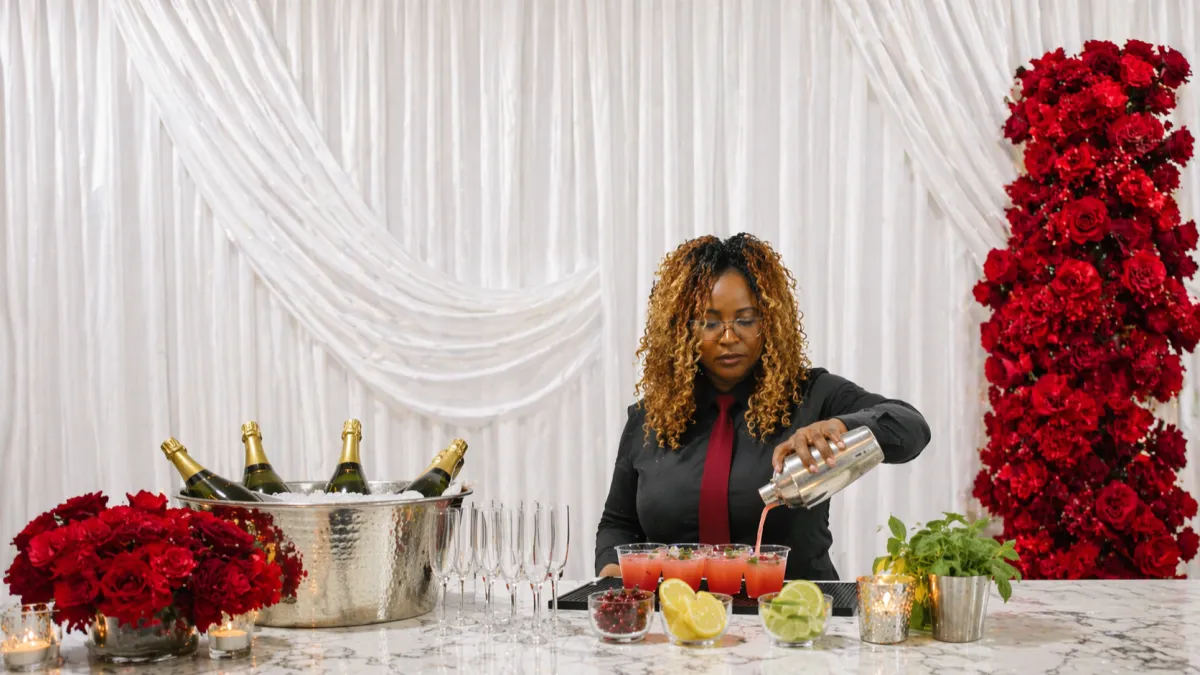 A tall glass filled with a red drink and garnished with lemons and