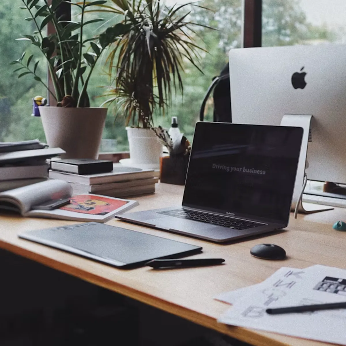 Image of an office desk with work materials and computers.