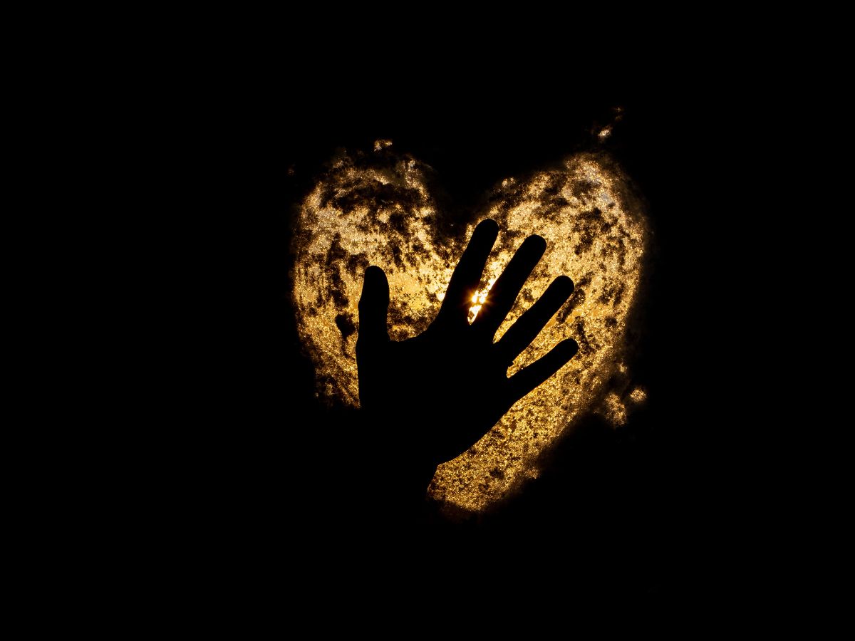 A hand resting on a heart in warm light, permission to want what you want