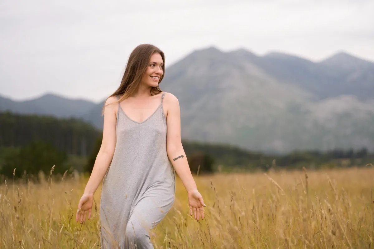 Woman standing peacefully overlooking the mountains after healing from survival mode and emotional exhaustion.