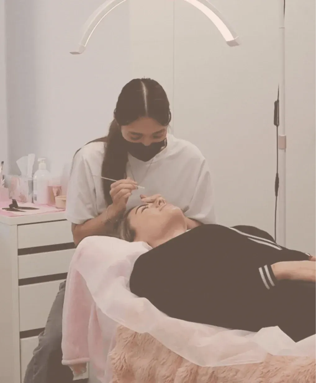 Client receiving an eyebrow shaping treatment
