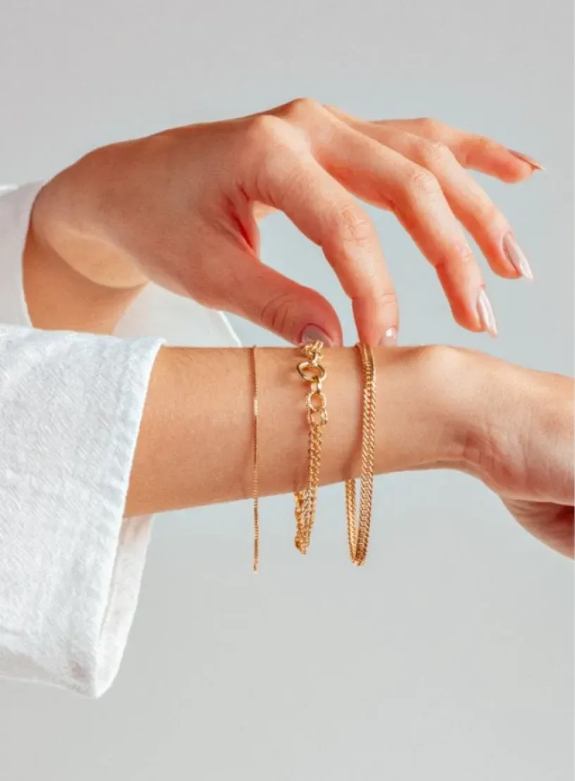 Client wearing gold permanent jewellery bracelets