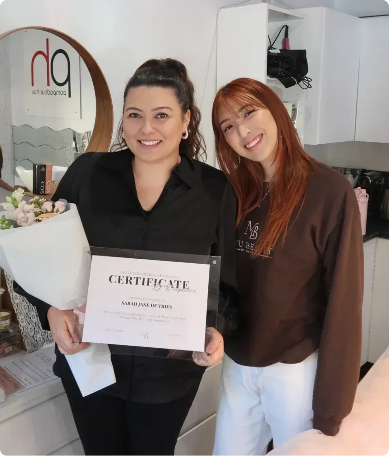 Maho and a student holding a training completion certificate