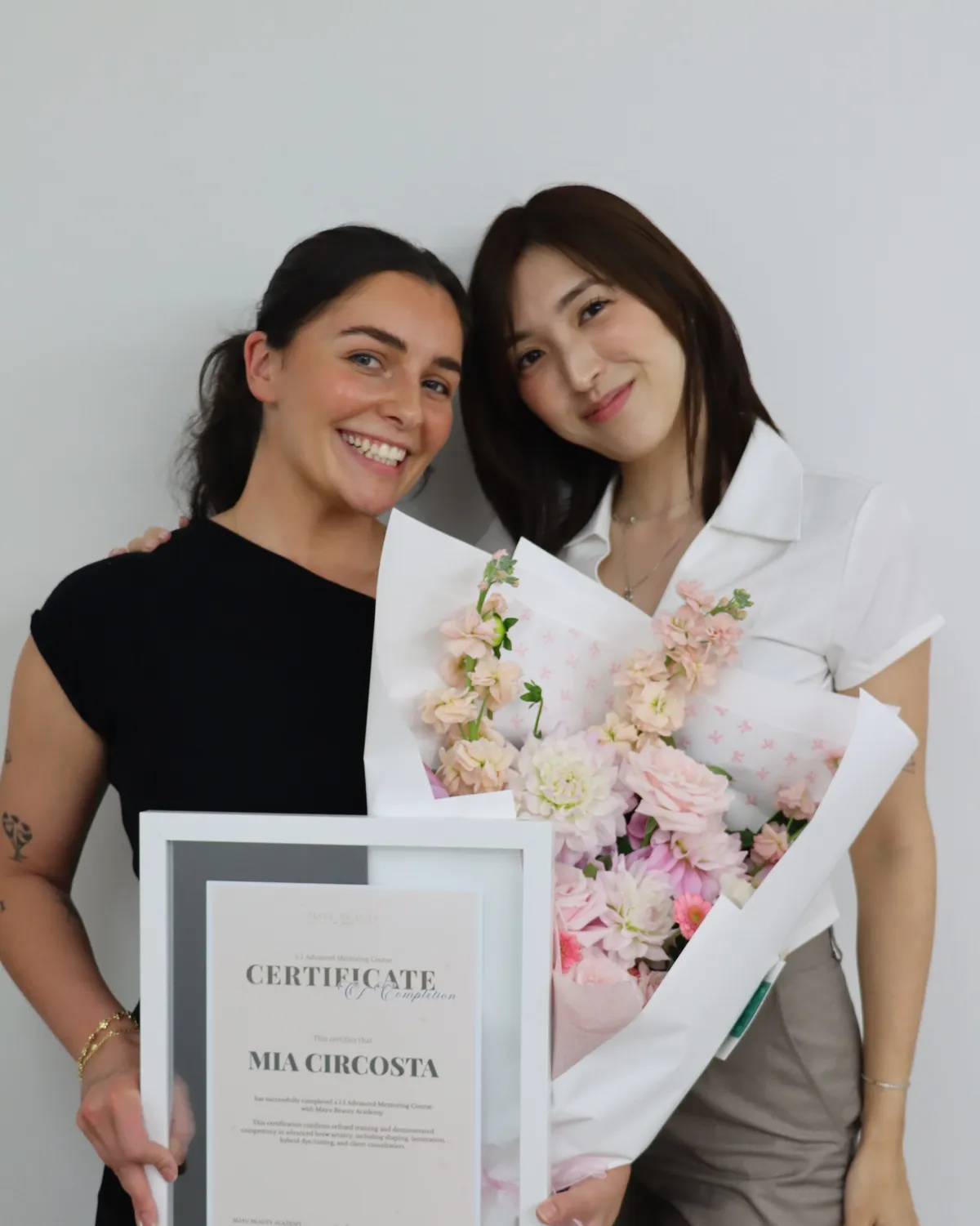 Maho and a student holding a training completion certificate