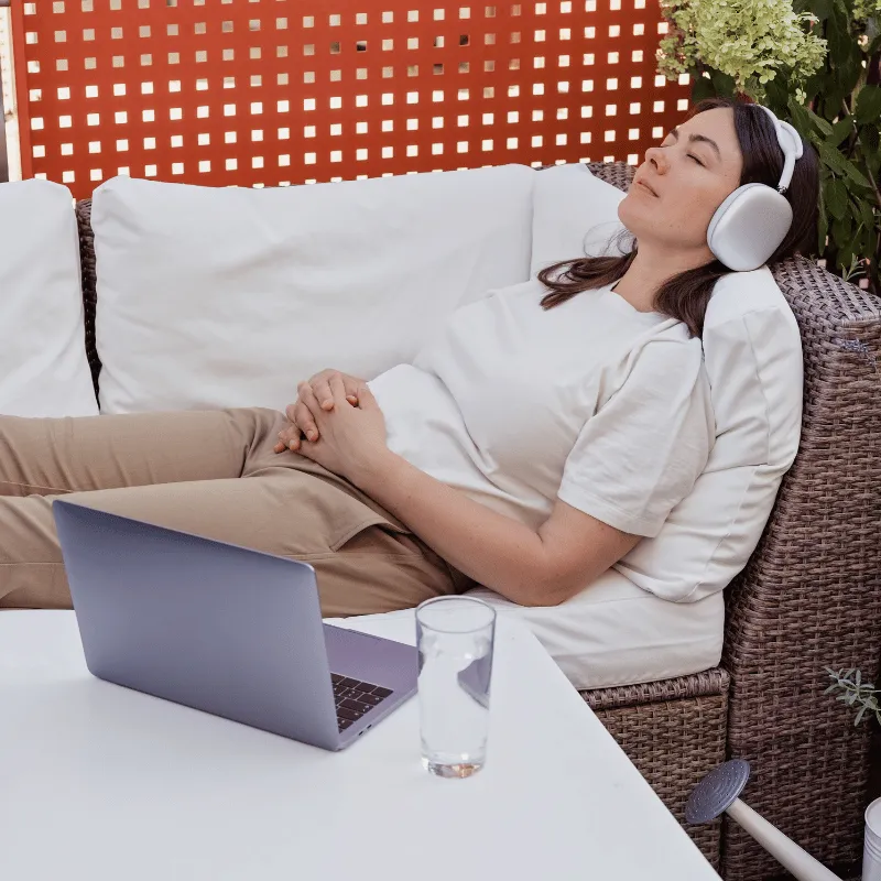 A woman lying down listening to hypnotherapy