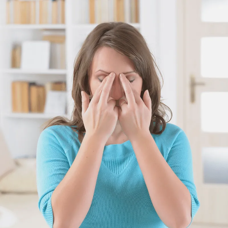 A woman touching her face using her two fingers of each hand