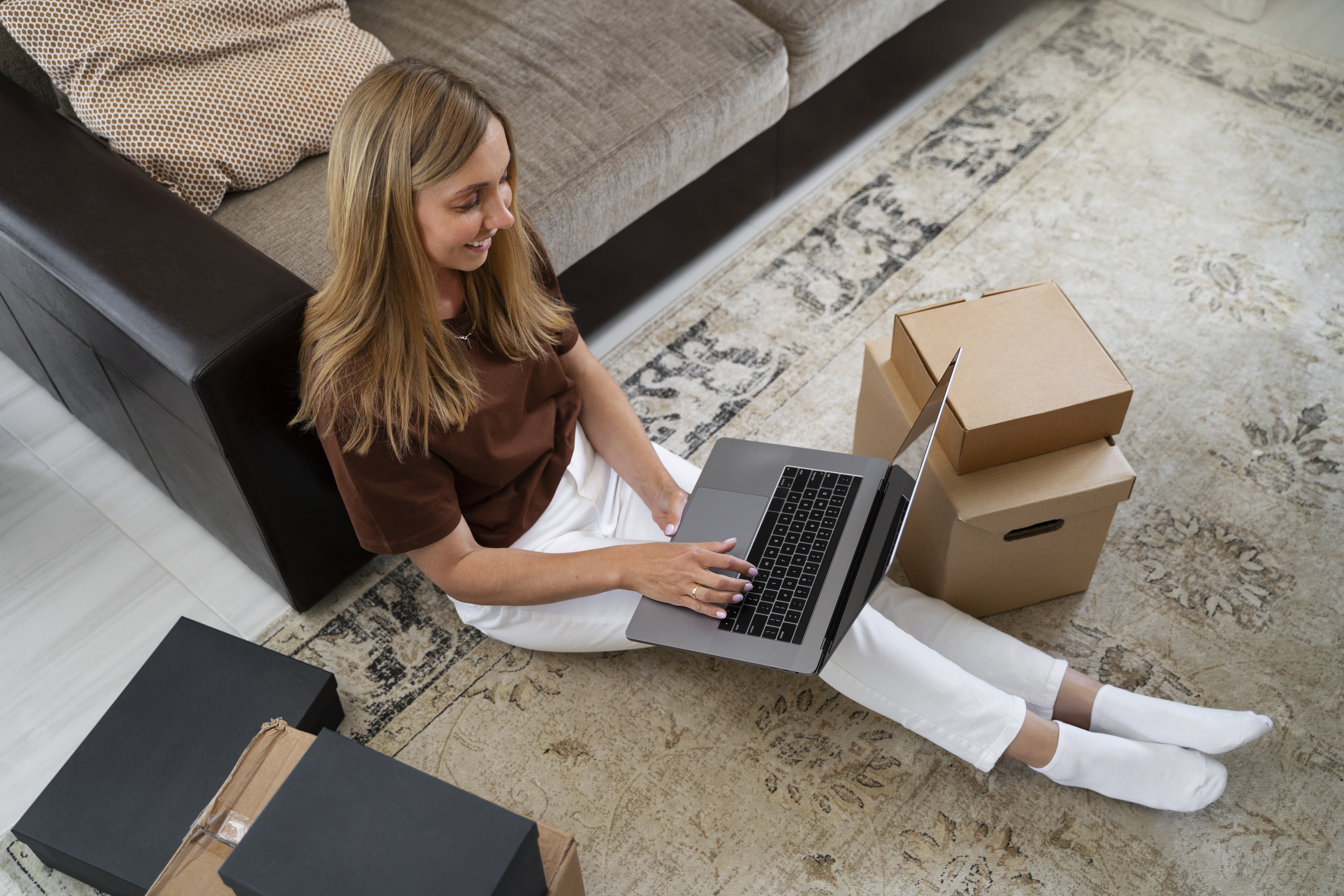 Woman working on laptop at home representing furniture and computer loans