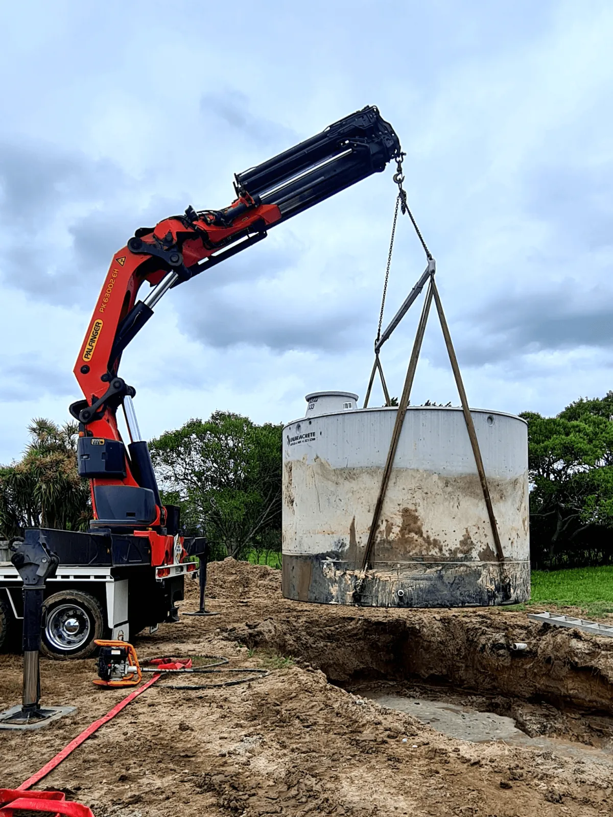 Hiab crane lifting a large water tank during a heavy lifting project in Waikato
