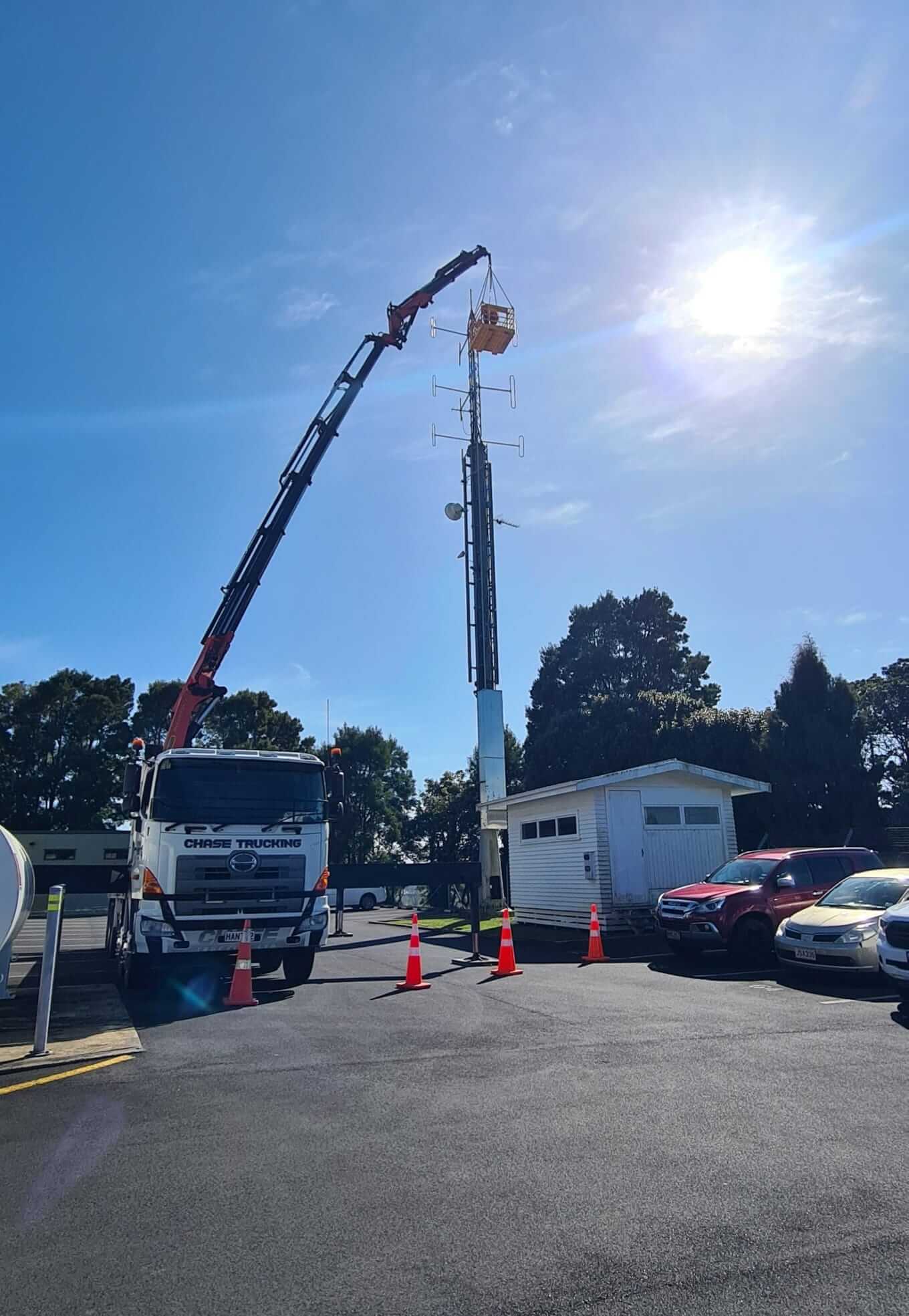 Hiab crane lifting equipment onto a telecommunications tower in Hamilton, Waikato