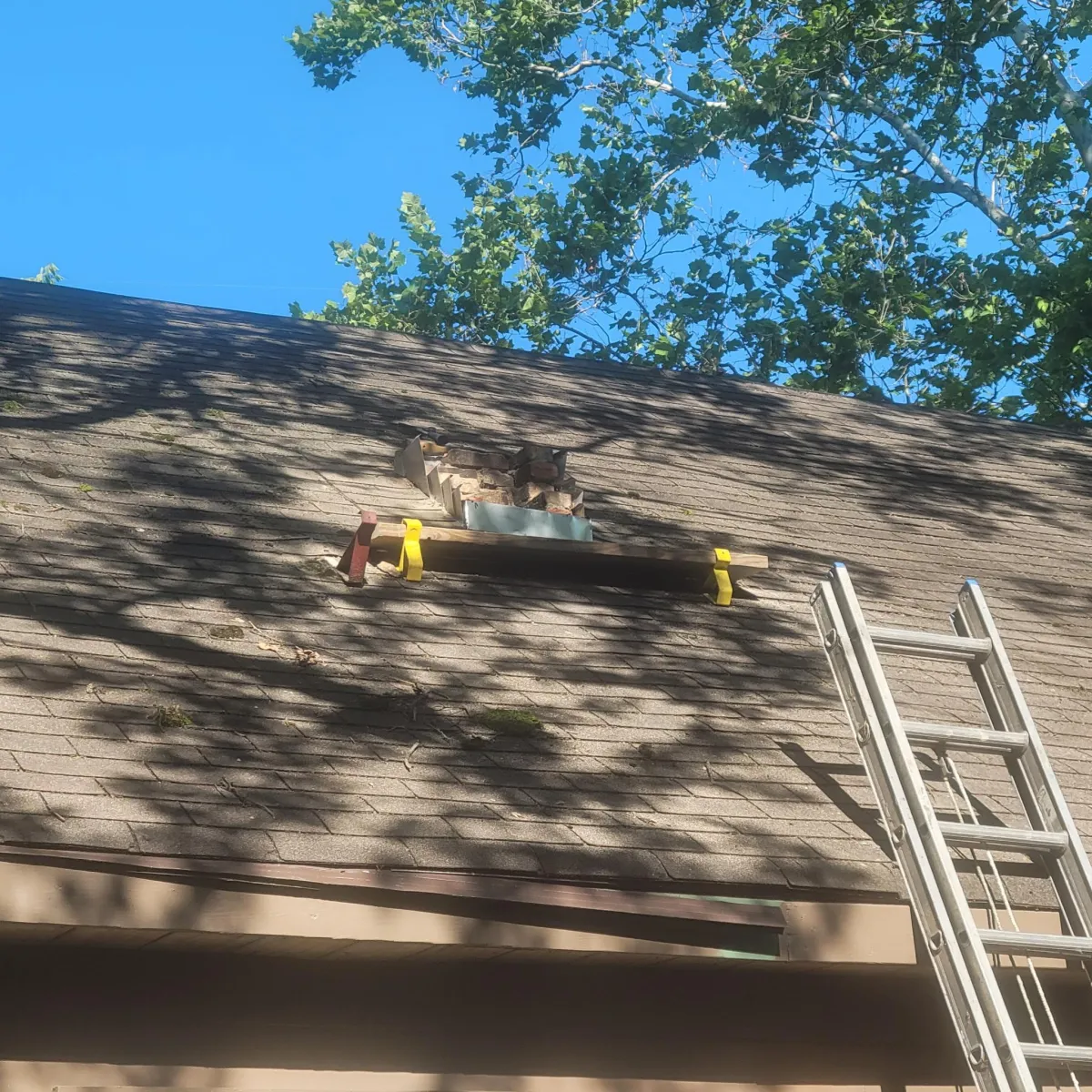 Roof with shingles missing and lifted up due to wind storm damage in the Cincinnati area.