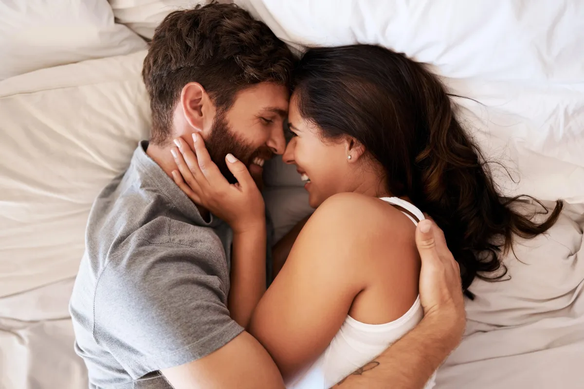 a male and female couple holding each other in their arms and smiling