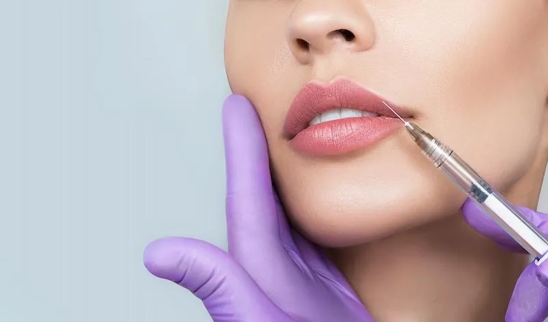 woman receiving dermal filler injection for beautiful lips