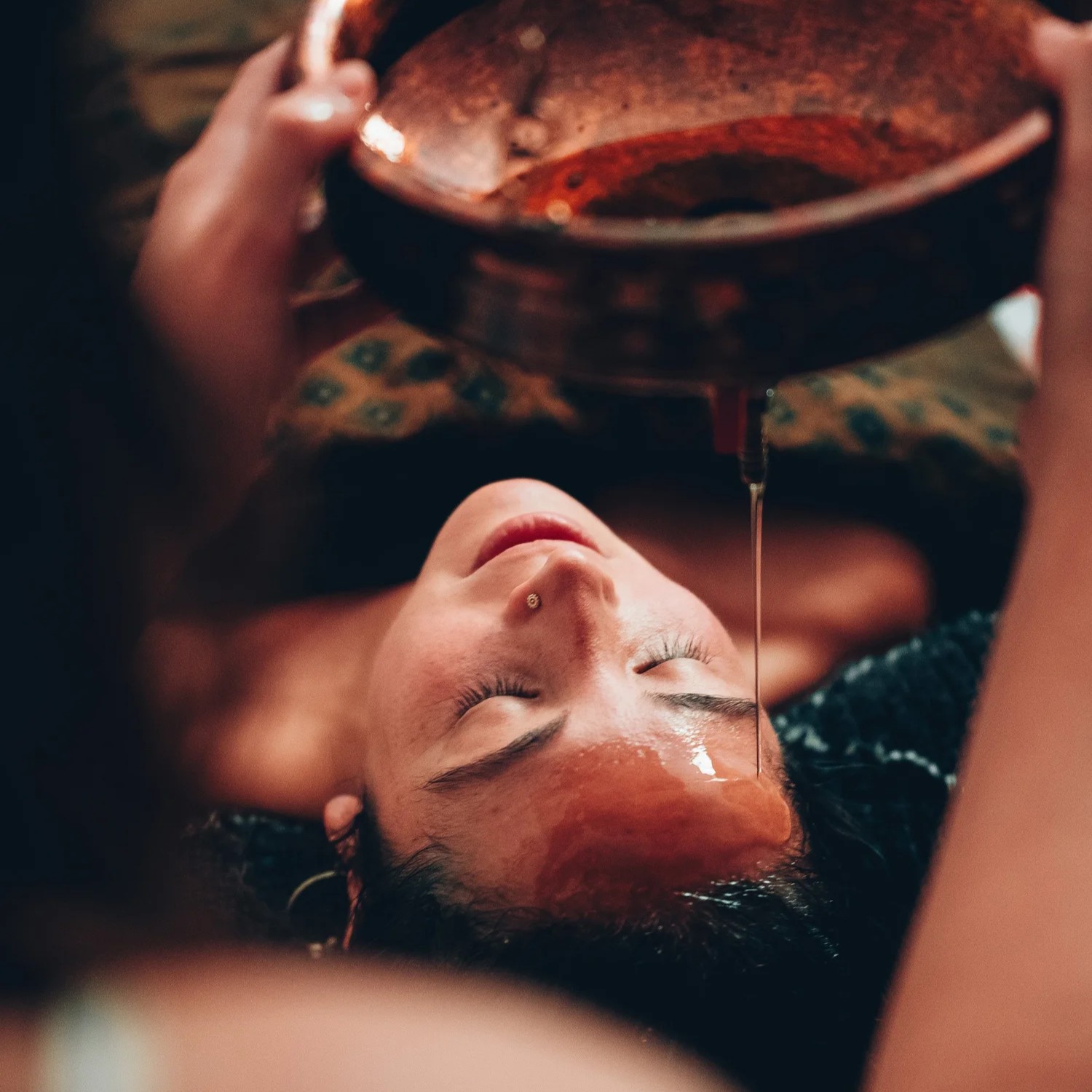 a person and a dog sitting on a hill overlooking a city
