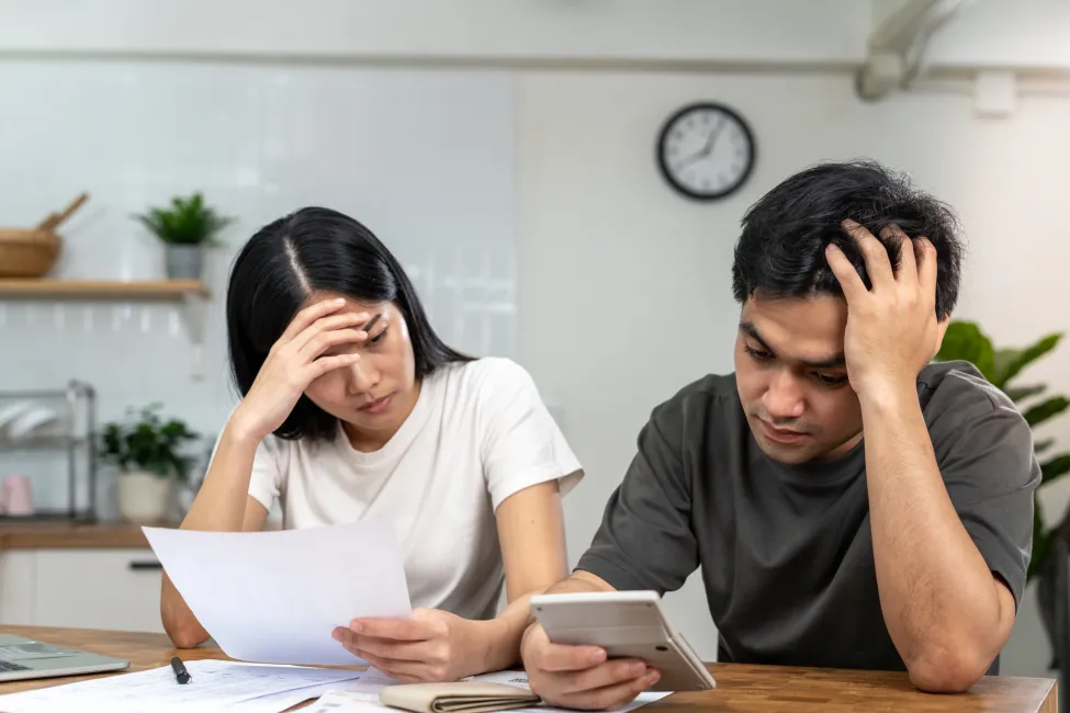 Couples are worried about debt and expenses. Stressful women and men receive bank loan invoices. credit card, water, electricity, telephone bills. No money and broke