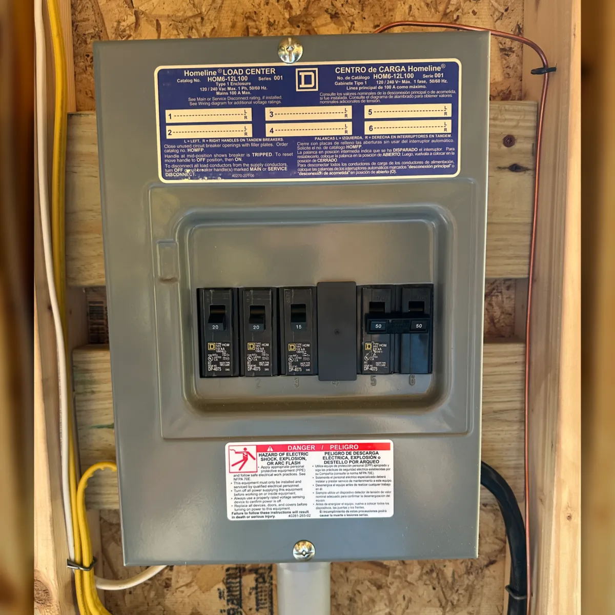 Electrical panel with circuit breakers, safety warning label, and load center specifications, relevant to electrical safety inspections for homeowners.