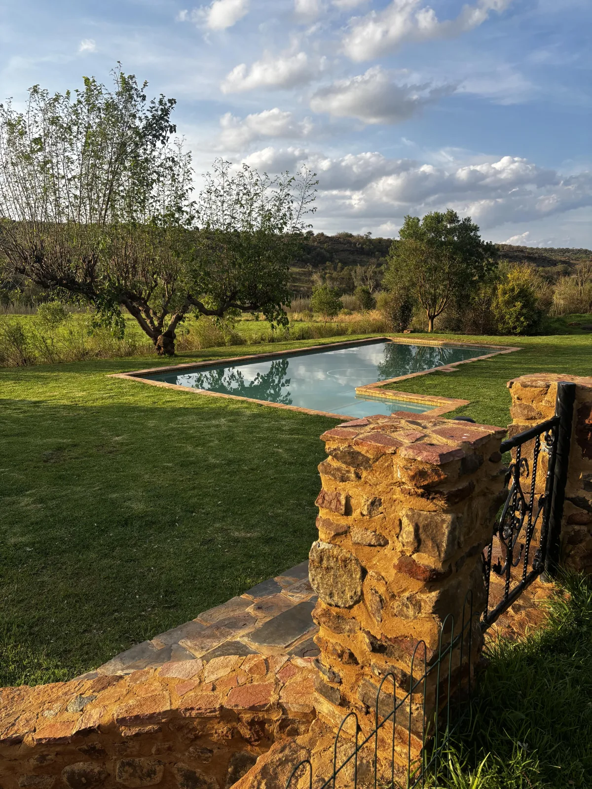Open grassy area at Oude Doornbosch Cottages, ideal for family activities and outdoor adventures with stunning views of the Magaliesburg Mountains.