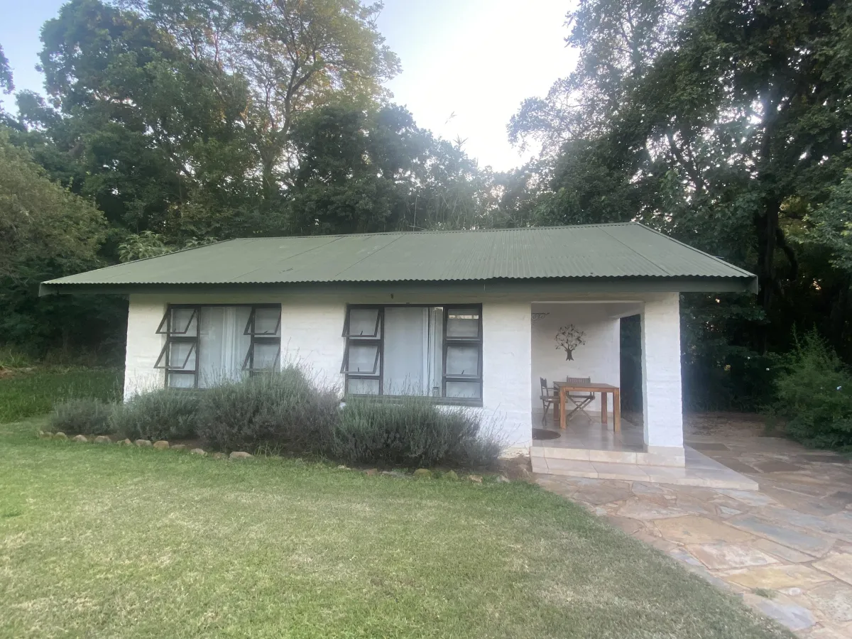 Bushwillow Cottage nestled among trees at Oude Doornbosch, offering a tranquil retreat.