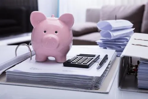 image of piggy bank on open notebook with calculator