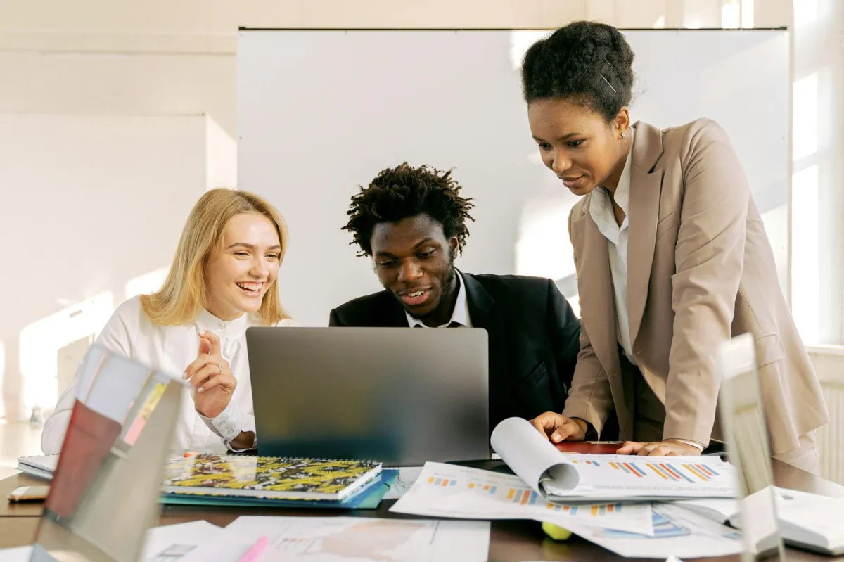 image of 3 smiling people gathered at computer