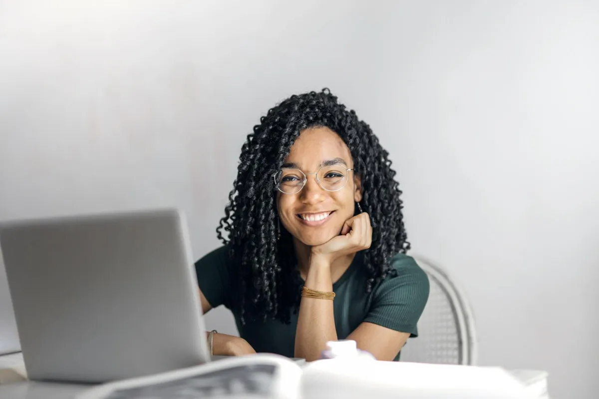 image of smiling woman sitting at table with computer