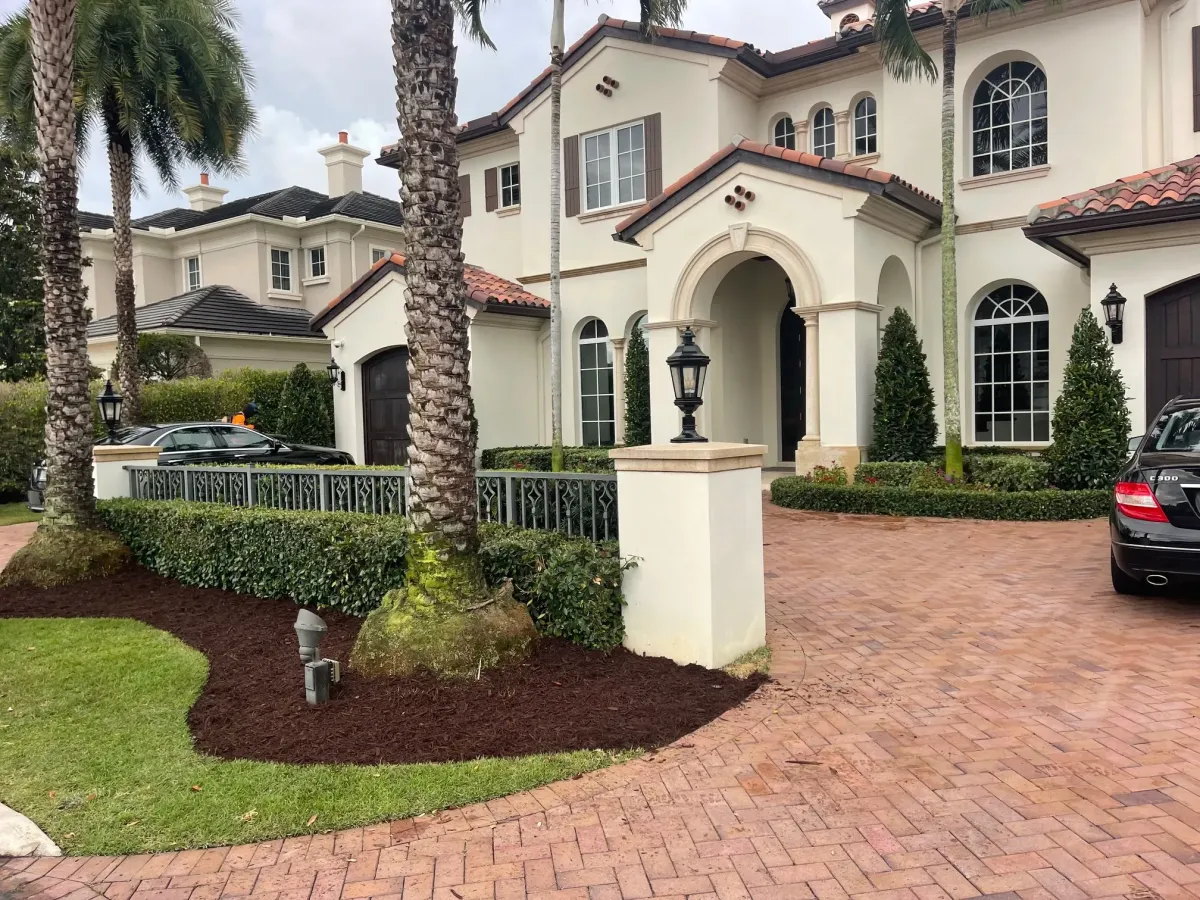 Luxury home landscaping with paver driveway and palm trees in Deerfield Beach – Quality Lawncare & Landscaping