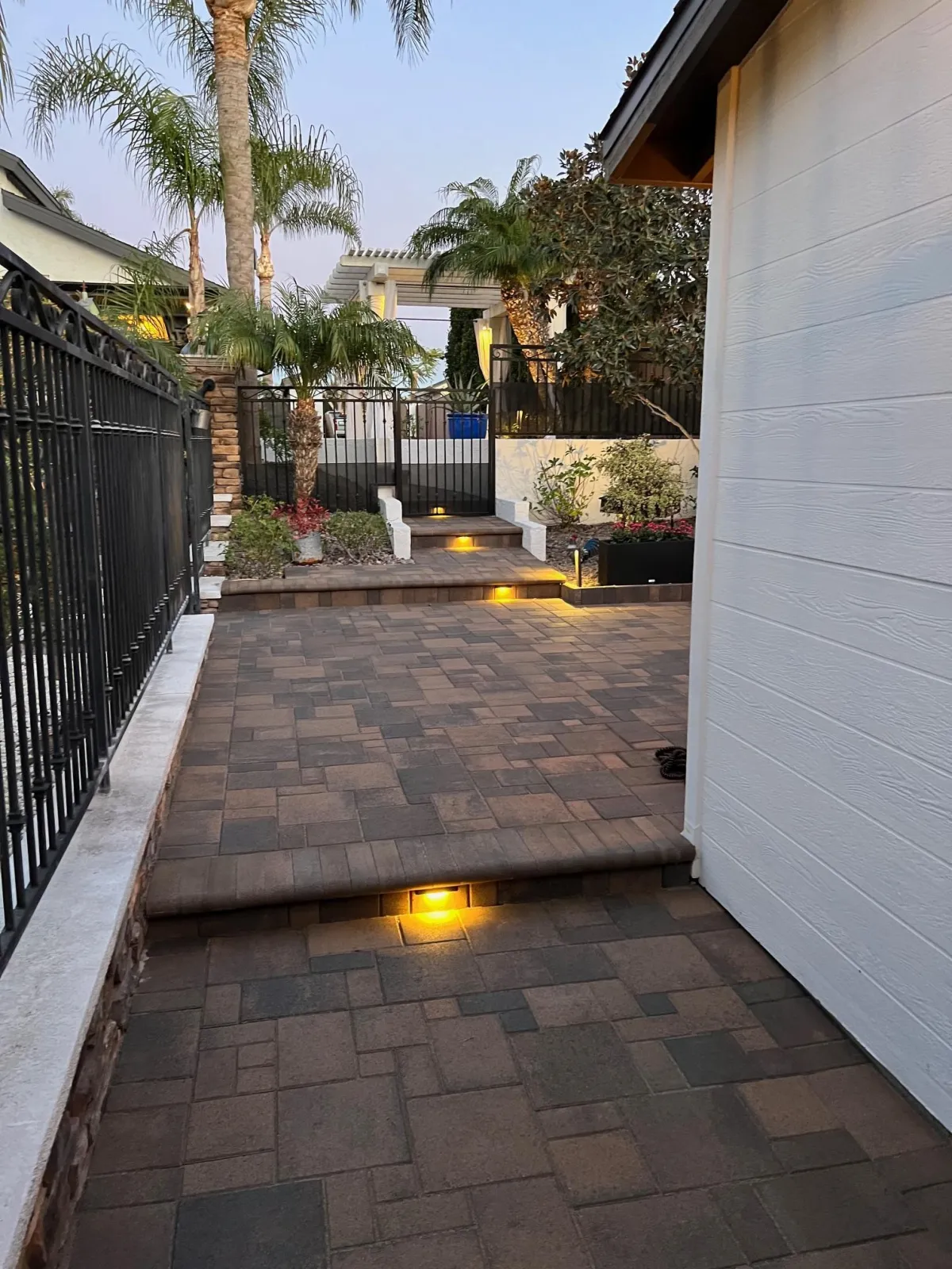 Stylized paver installation with lighted steps n a back patio.