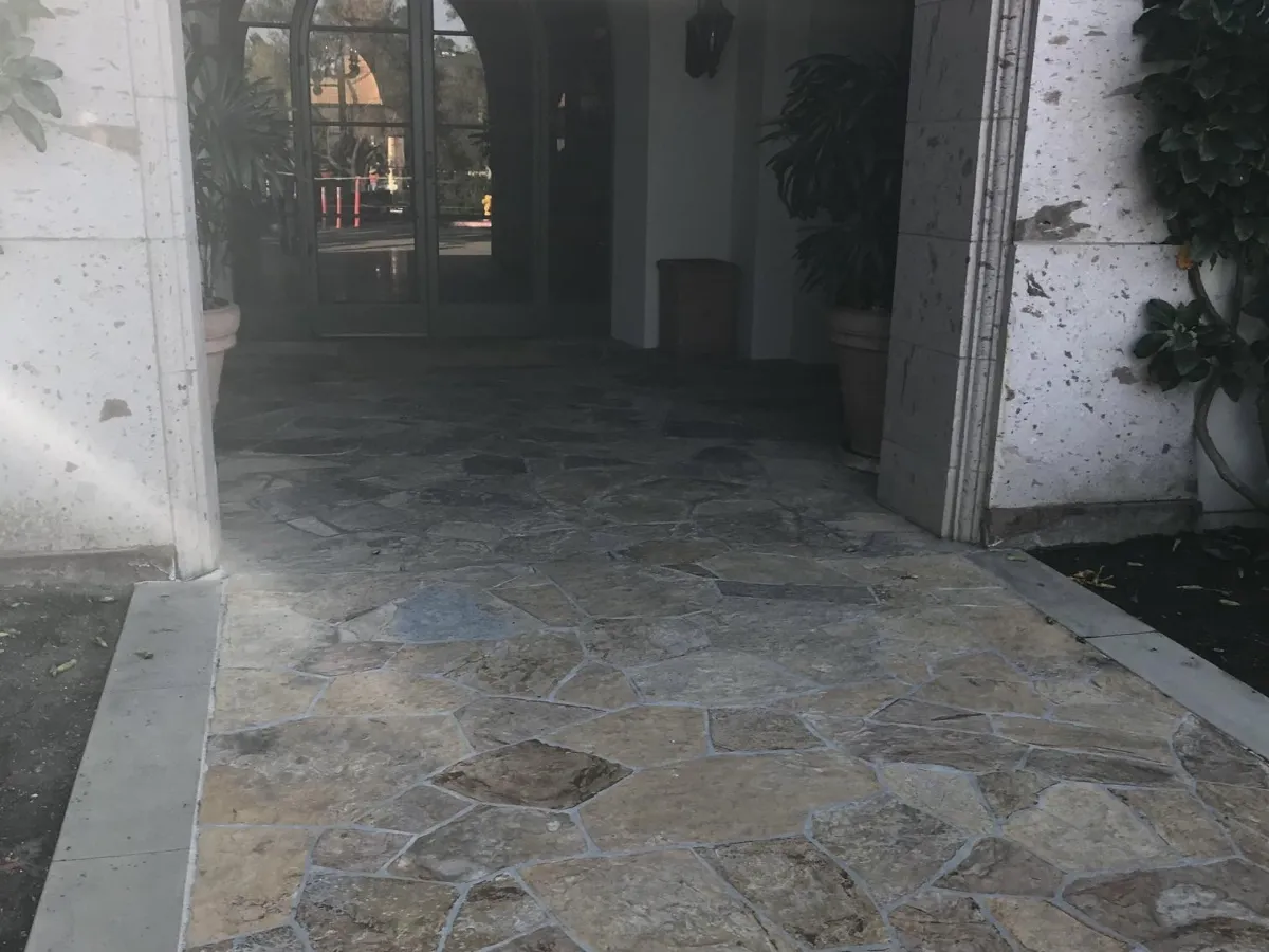 Archway entrance way with a flagstone floor outlined with concrete.