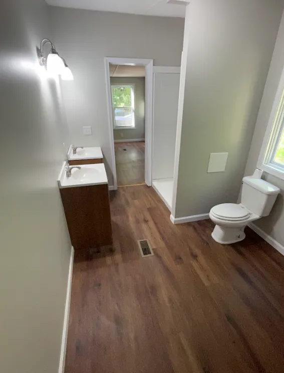 a bathroom with a toilet, sink and shower