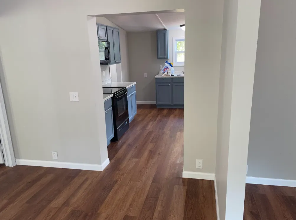 an empty kitchen and living room with hardwood floors