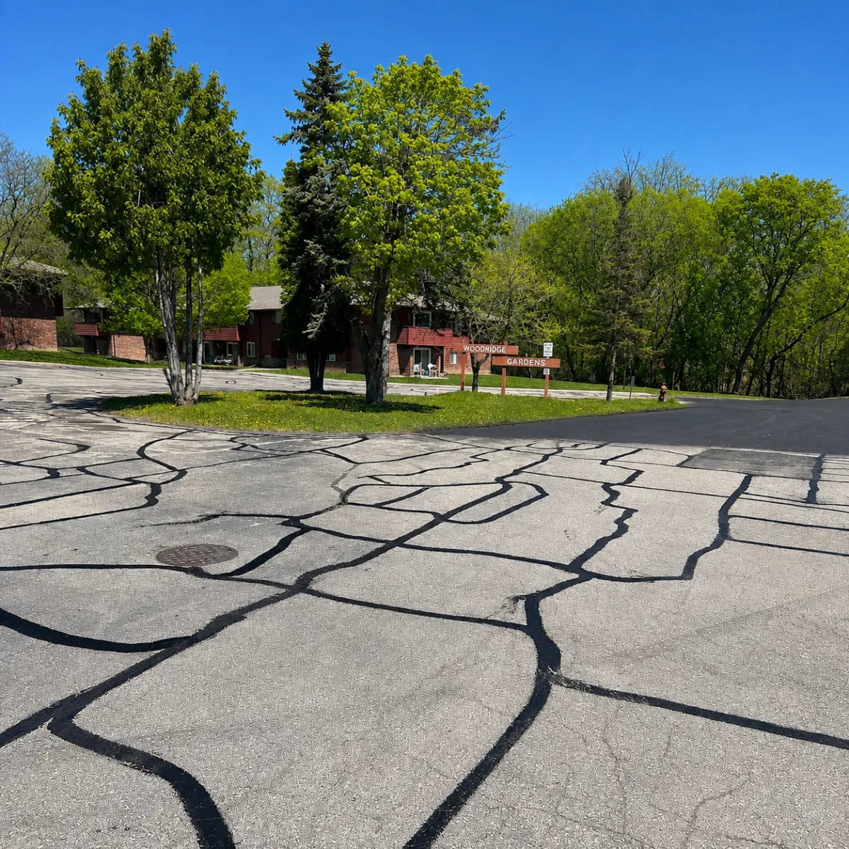 Crack-sealed commercial parking lot pavement in Wisconsin with extensive treated asphalt cracks