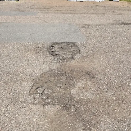 Potholes and localized asphalt pavement failure in a deteriorated commercial surface in Wisconsin