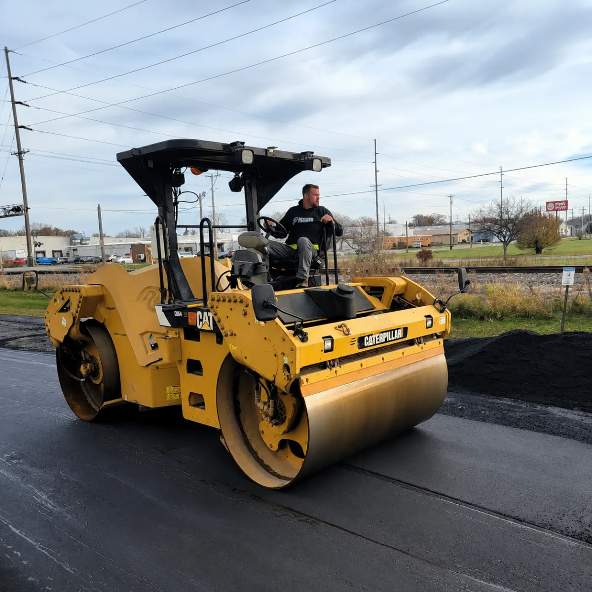 Asphalt roller compacting freshly paved asphalt during a roadway paving project