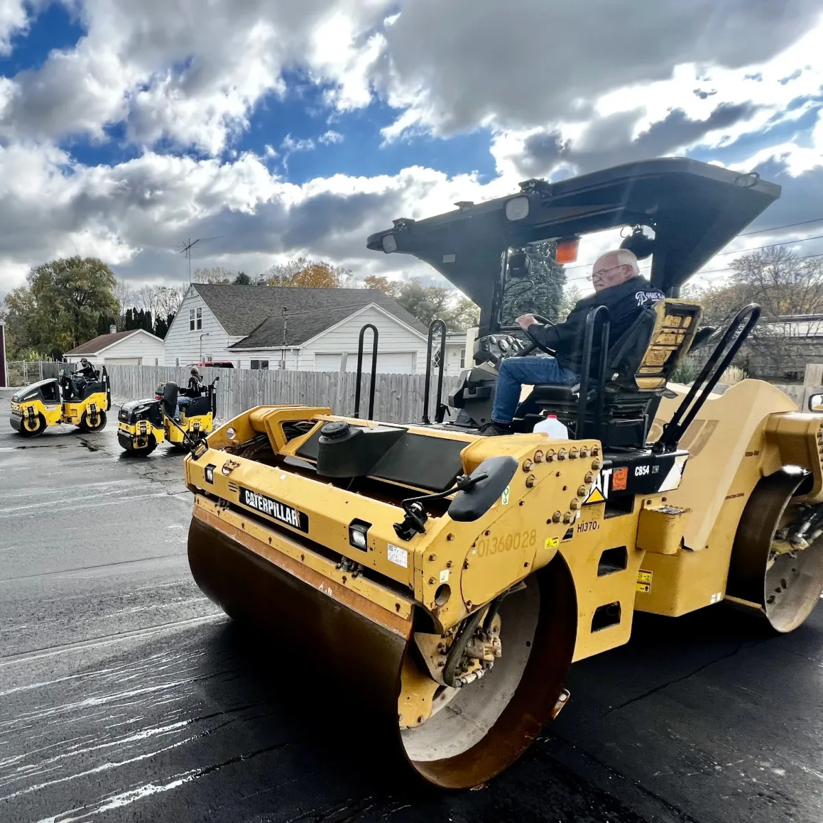 Asphalt rollers compacting freshly paved pavement during a commercial paving project.