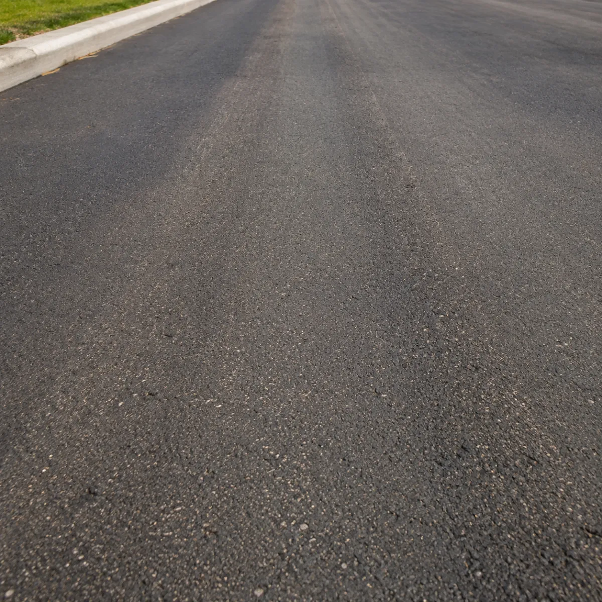 Fresh microsurfacing applied to asphalt pavement, creating a smooth renewed driving surface.