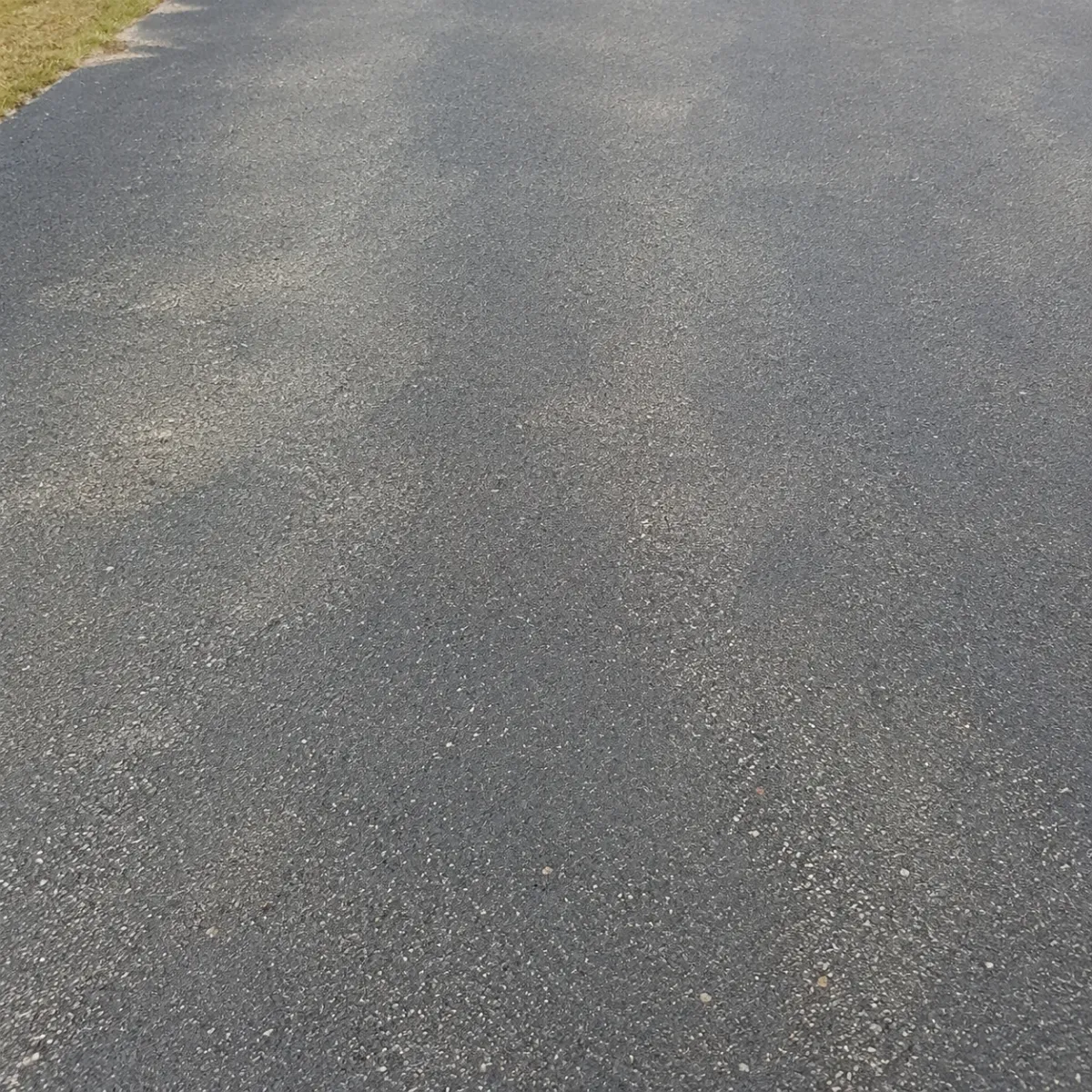 Close-up of a smooth asphalt pavement surface after microsurfacing treatment.