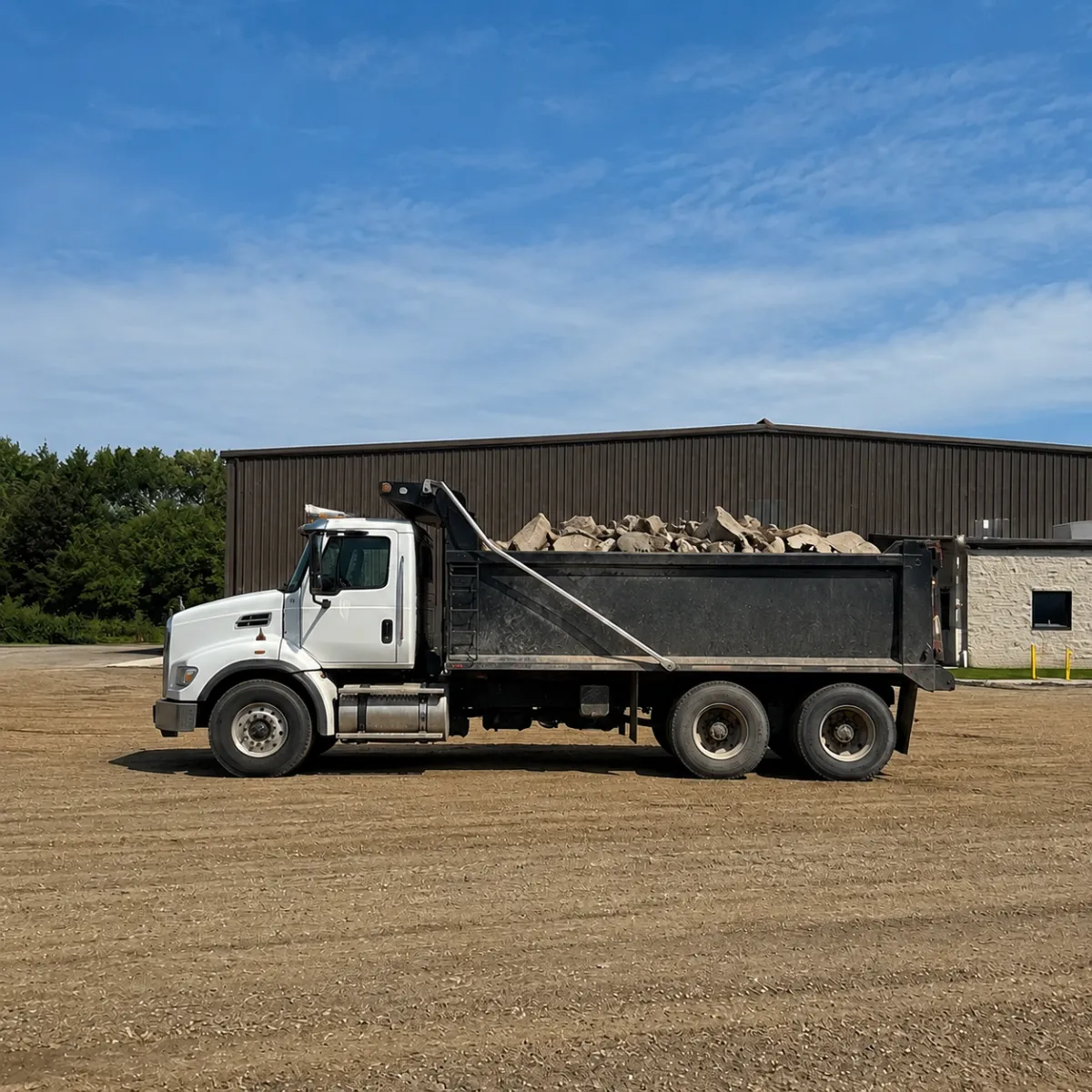 Dump truck hauling broken concrete debris from a commercial concrete demolition and removal project.