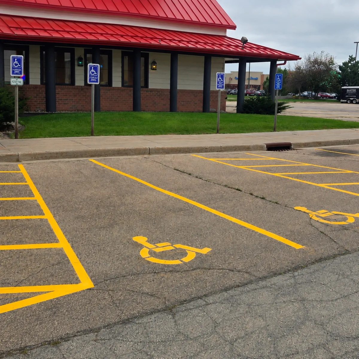 Fresh yellow ADA pavement markings and accessible parking access aisles in a Wisconsin parking lot