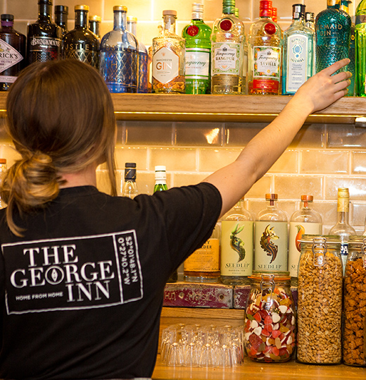 A woman getting a drinks bottle from a shelf for a restaurant in Maulden Bedfordshire commercial photography