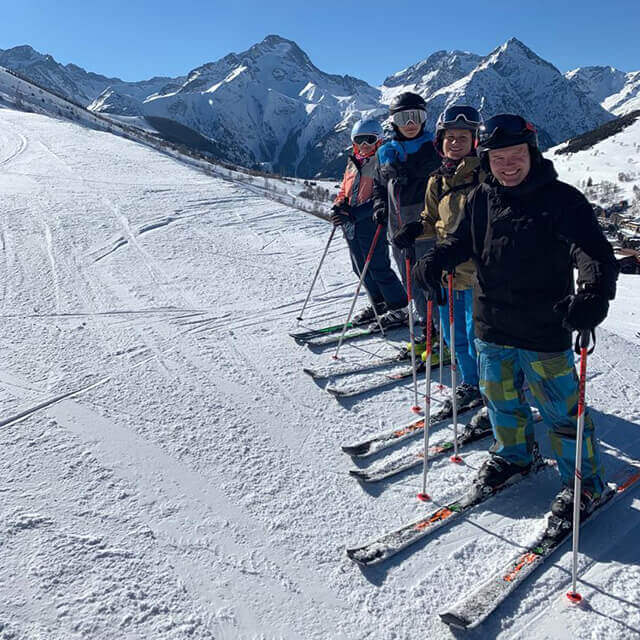  Becky Kerr Photography with her family skiing , blue sky and mounties in the background unties 