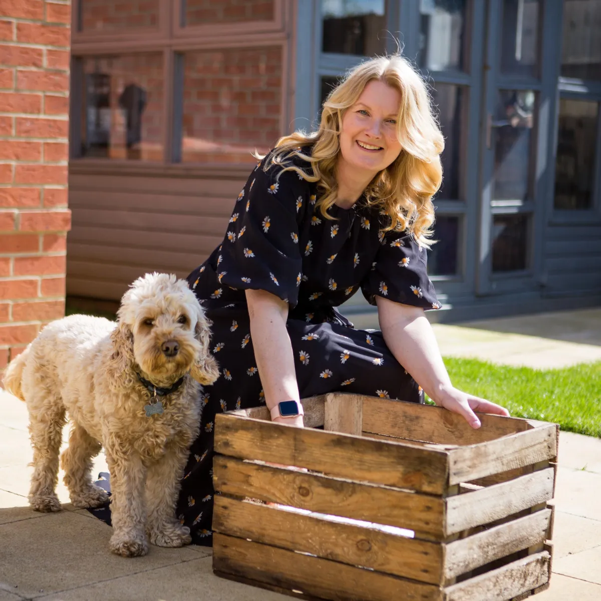 Candle maker and her dog looking to camera smiling for her brand photos. 