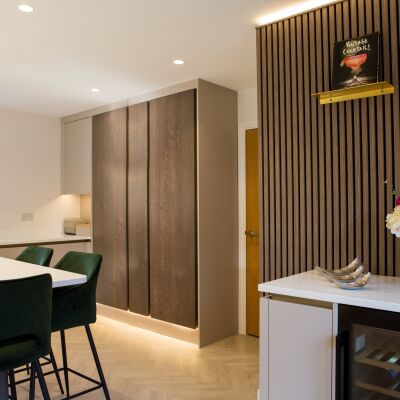 dark brown cupboards and dark green chairs in the foreground . Photographed for branding.